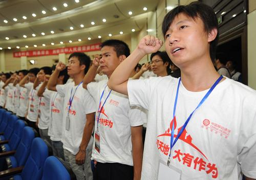 7月31日,即将赴任的大学生们在培训结业式上宣誓扎根基层,做出成绩。新华社记者 程敏 摄